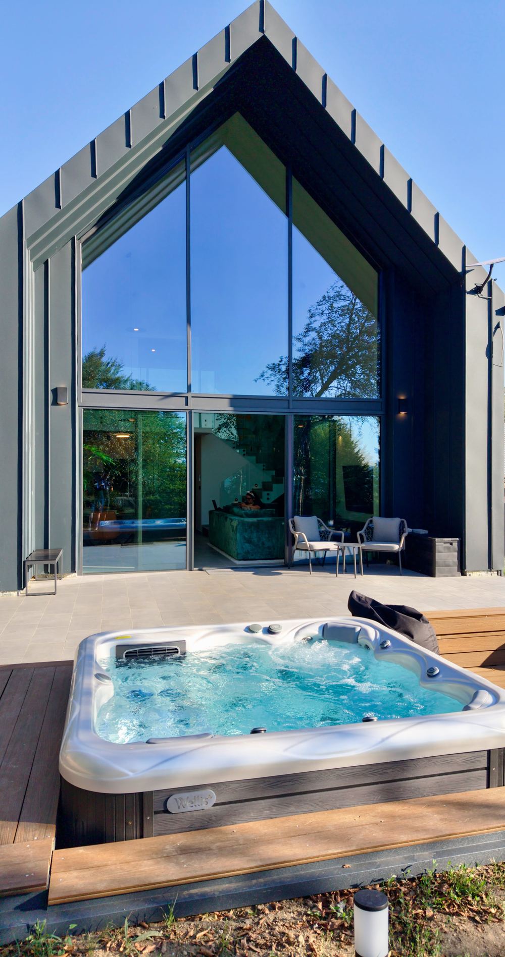 The glass front and the hot tub deck by day