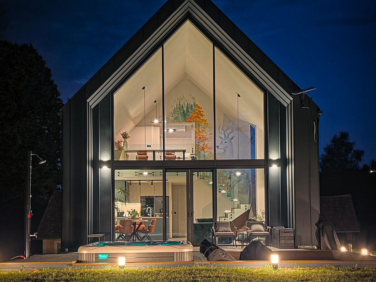The villa at night, the glass front lit from inside